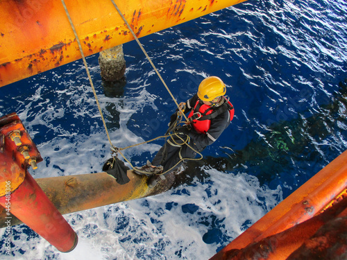 Canvas Print Male worker rope access  inspection of thickness offshore drill yellow