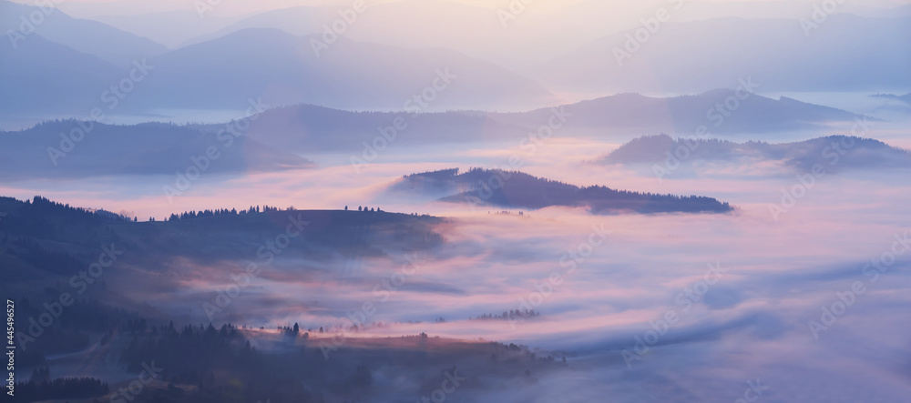 mountain valley in blue mist at the early morning