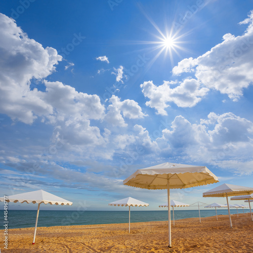 white sun umbrella on sandy sea beach at the sunny day © Yuriy Kulik