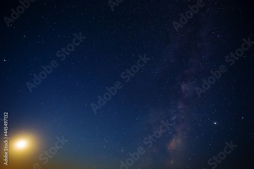 night starry sky with milky way and rising moon