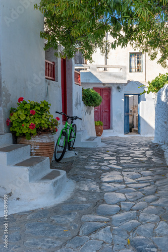 Traditional cycladitic alley with a narrow street, whitewashed houses and blooming flowers in Chora Amorgos Greece