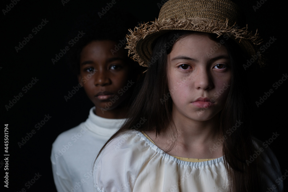 white and Dark skinned kids looking at camera on black background, different ethnicity concept, Caucasian, African, selective focus white and Dark skinned kids looking at camera on black background, different ethnicity concept, Caucasian, African, selective focus
