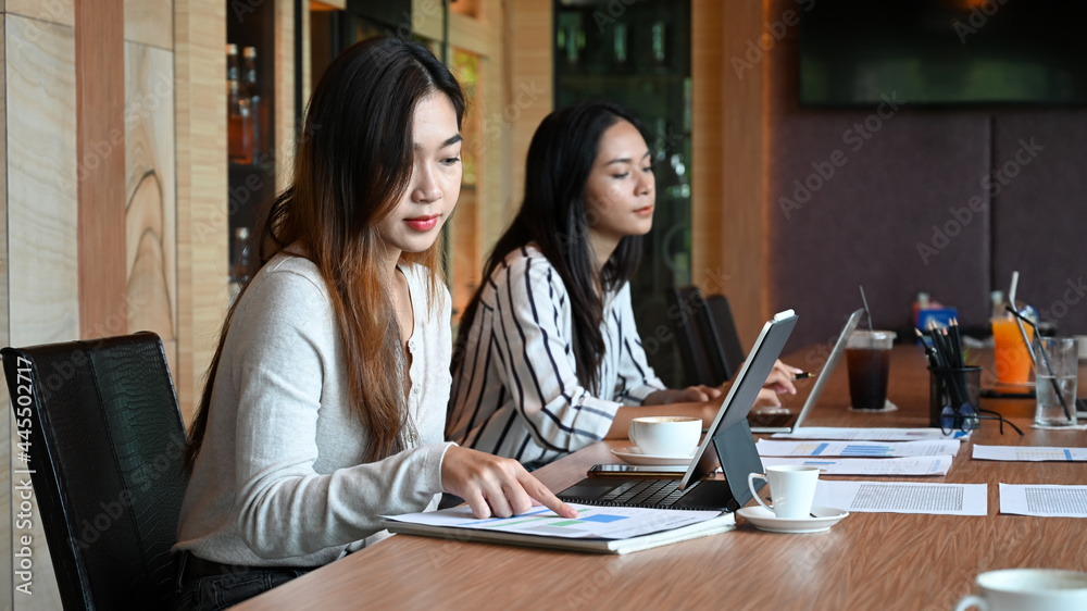 Two young businesswoman sitting in meeting room. Two young businesswoman sitting in meeting room.
