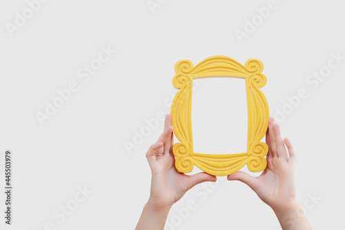 a hand holds a yellow frame from the TV series friends photo