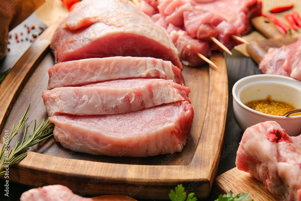 Board with slices of raw pork meat on wooden table, closeup