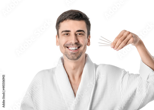 Young man with cotton buds on white background