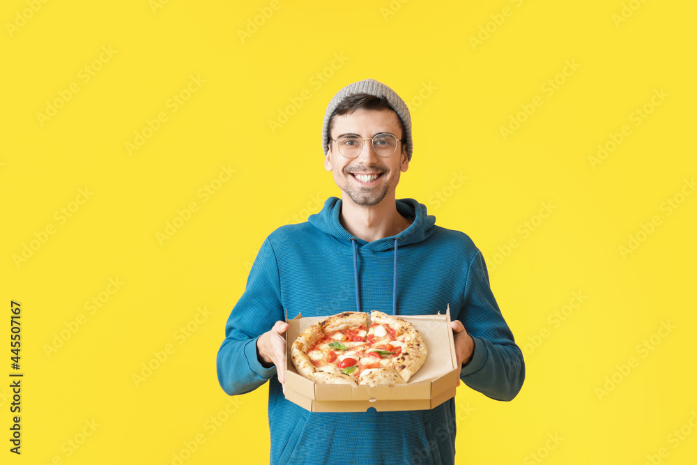 Handsome young man with tasty pizza on color background Handsome young man with tasty pizza on color background