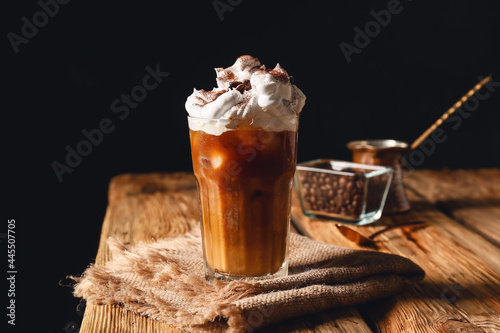 Glass of iced coffee on wooden table photo