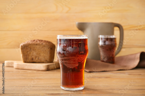 Glass of fresh kvass on wooden background