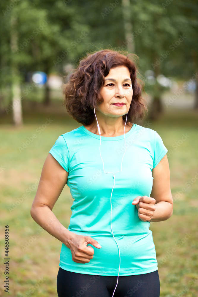 Senior middle age female woman running outdoors in a park Senior middle age female woman running outdoors in a park