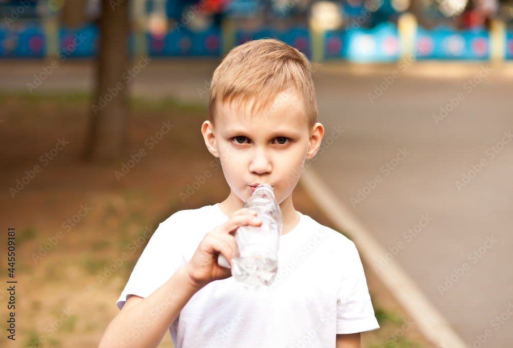Little boy kid drinking water from a bottle outdoor in a park Little boy kid drinking water from a bottle outdoor in a park