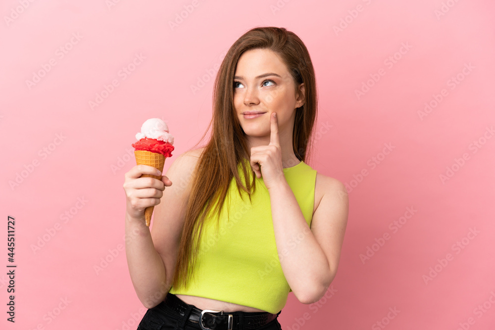 Teenager girl with a cornet ice cream over isolated pink background thinking an idea while looking up Teenager girl with a cornet ice cream over isolated pink background thinking an idea while looking up