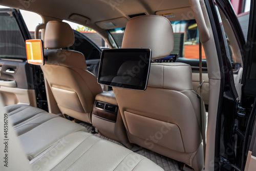 Car inside. Multimedia screens or TV displays for rear passenger seats. Luxury car interior with leather seats.