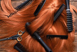 Hairdressing salon concept abstract background. Redhead women wig and combs on the hairdresser table flat lay background.