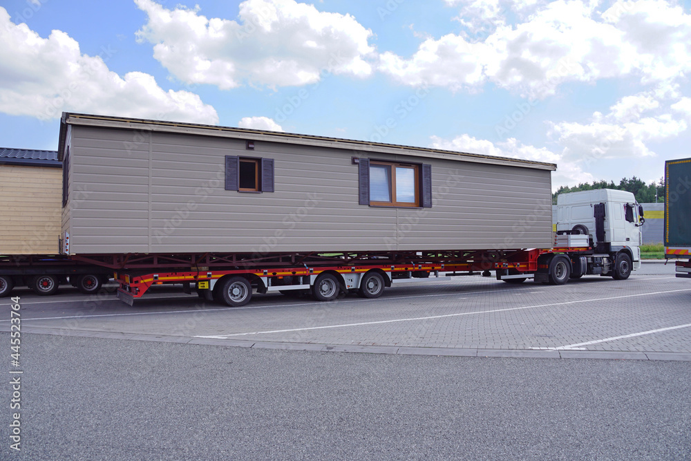 Oversized cargo or exceptional convoy (convoi exceptionnel). A truck with a  special semi-trailer for the transport of oversized cargo - transport of  finished houses. Photos | Adobe Stock