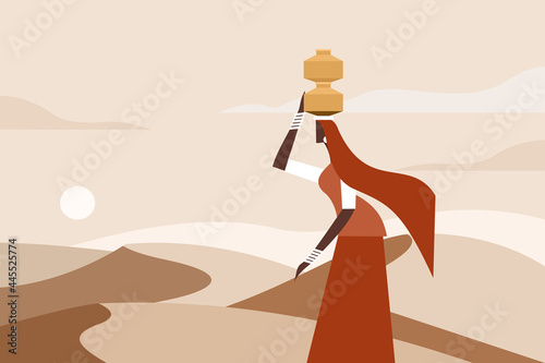 A woman walks with water pots on her head in a desert