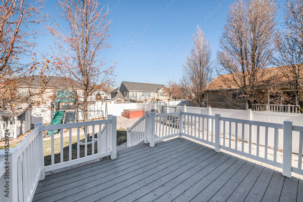 Deck of a house with a view of a playground in the backyard