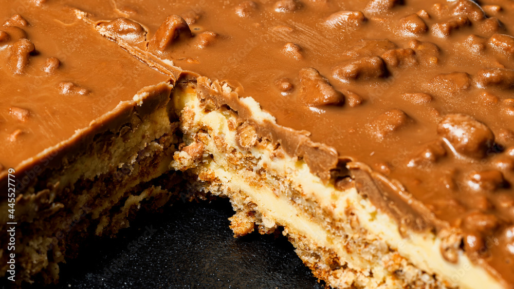 Slice of Swedish almond and chocolate cake with filling and nuts