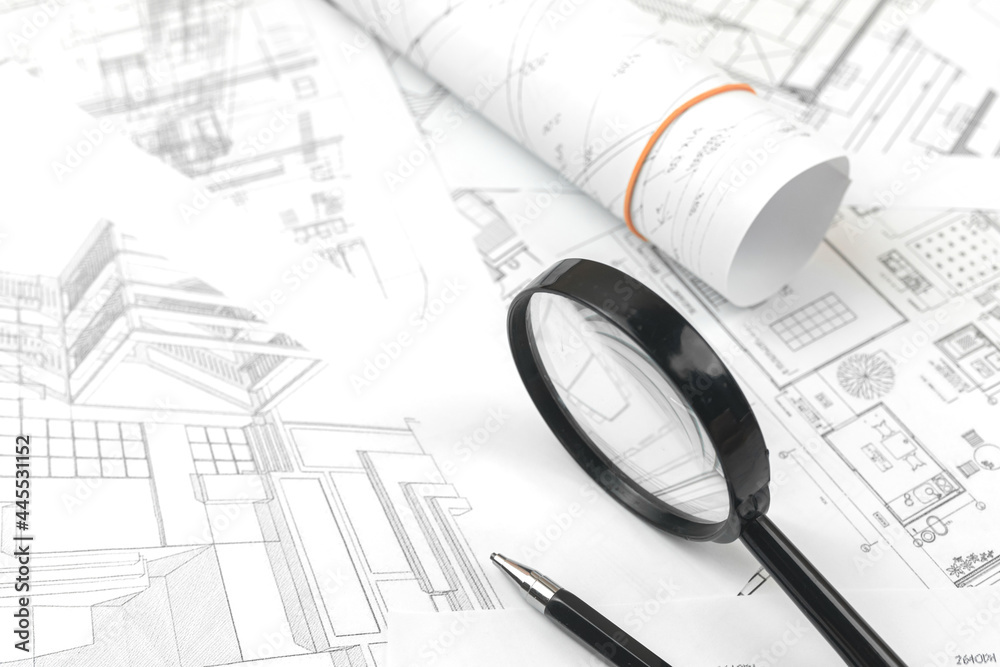 Work project paper blueprints on the office table with pen pencil and magnifying glass Work project paper blueprints on the office table with pen pencil and magnifying glass