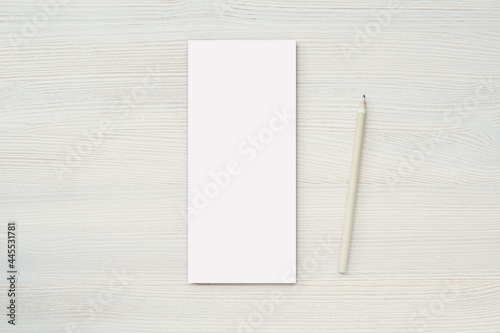 Skinny notepad mockup, vertical notebook for note paper, list, reminder, menu design presentation, minimal composition with pencil on white wooden background.