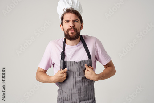 Cheerful chef in an apron industry work in a restaurant light background
