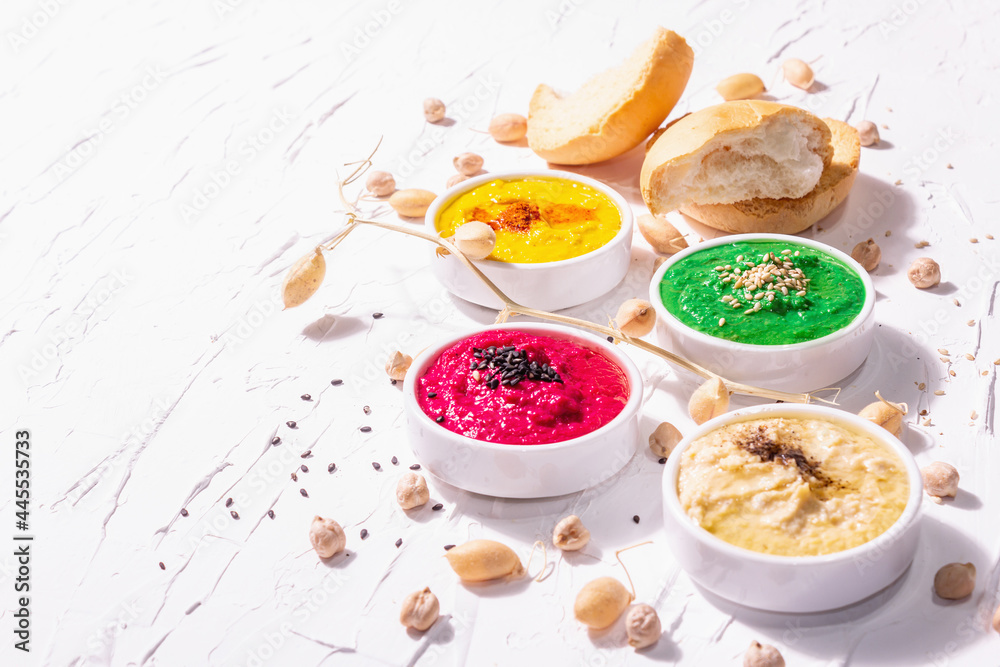 Various hummus dips, the flat lay of hummus in different colors with spinach, beetroot, turmeric and vegetables Various hummus dips, the flat lay of hummus in different colors with spinach, beetroot, turmeric and vegetables