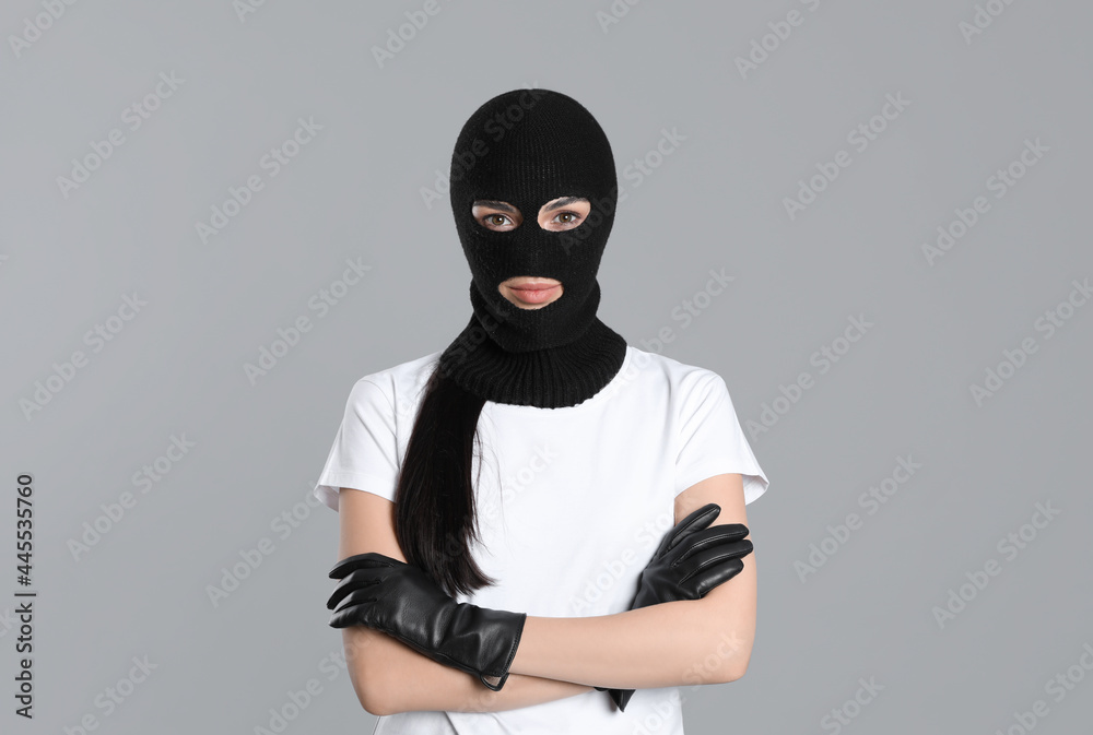 Woman wearing knitted balaclava on grey background Woman wearing knitted balaclava on grey background