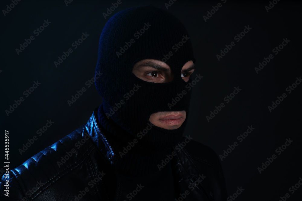 Man wearing knitted balaclava on black background Man wearing knitted balaclava on black background