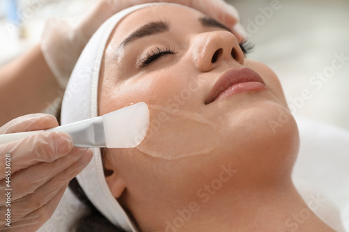 Young woman during face peeling procedure in salon, closeup photo