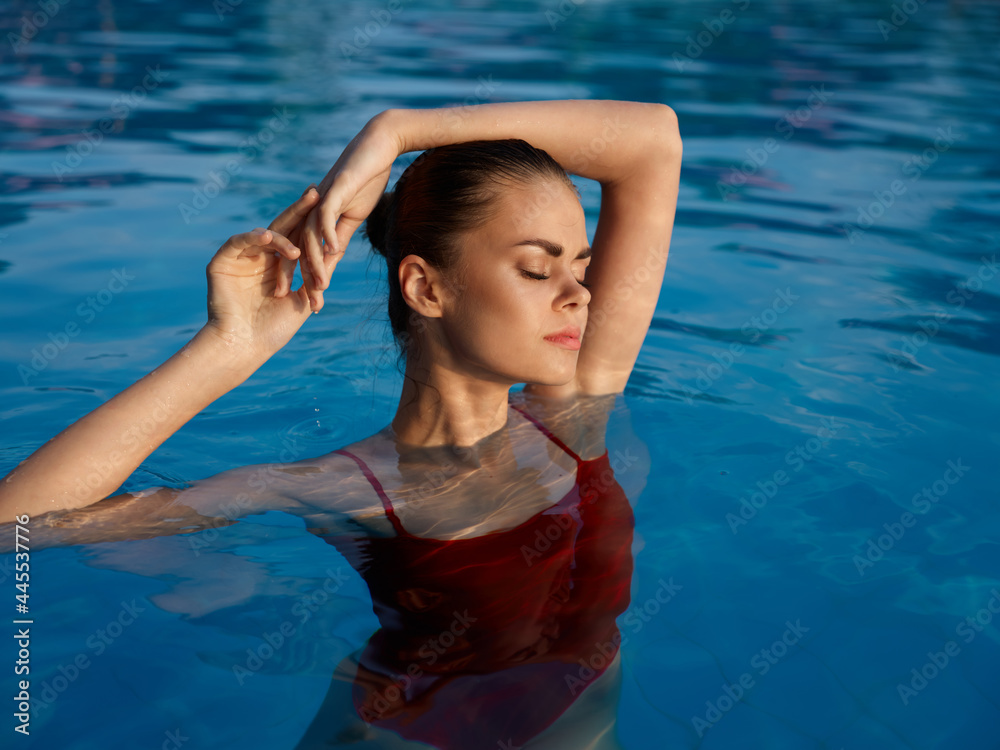 woman in red swimsuit in the pool and glamor luxury enjoyment