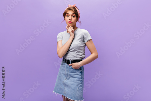 Lady in good mood looks into camera on isolated background. Teenager with pink headband in stylish outfit posing on purple backdrop.. © Look!