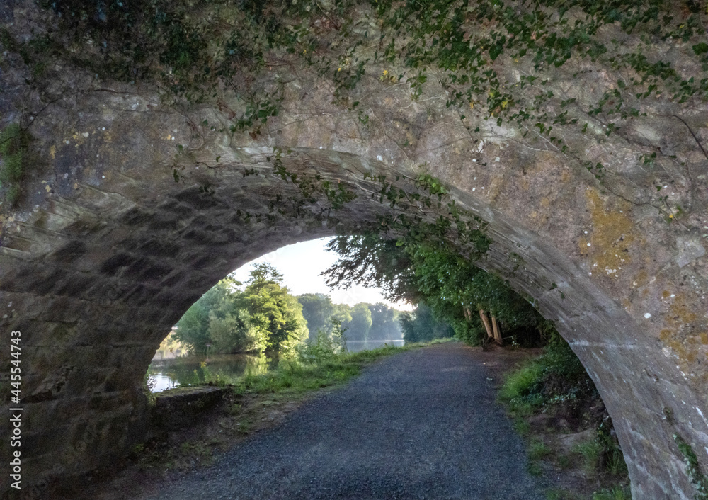 Vue sur une rivière sous l'arche d'un pont en pierre