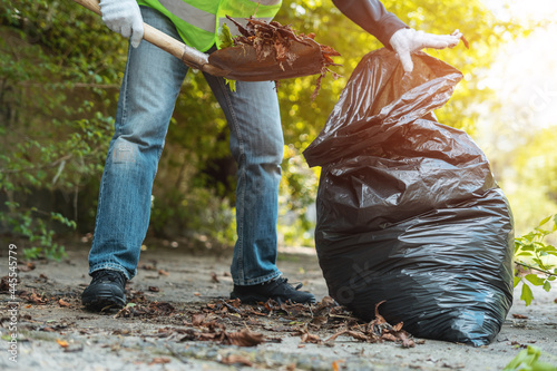 Fotografie man volunteer clean up park or collect foliage with shovel in garbage bag