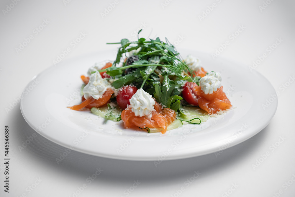 closeup of salad with salted salmon, cream cheese or arugula on white background closeup of salad with salted salmon, cream cheese or arugula on white background