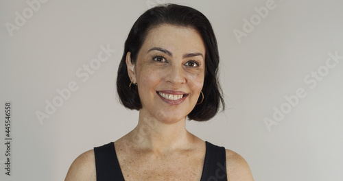 Fotografie Attractive middle aged woman with beautiful smile on yellow wall
