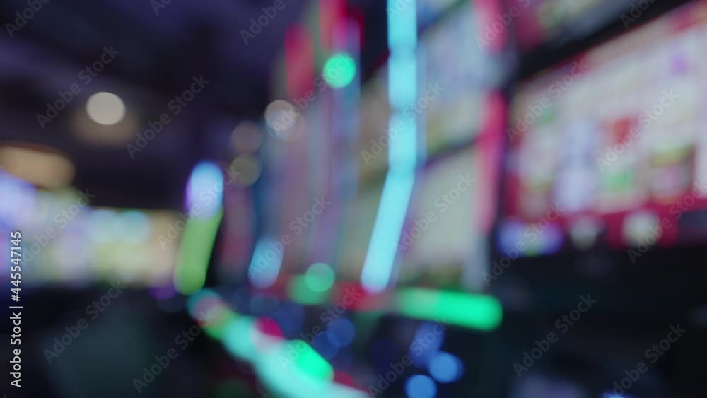 Blurry Shot Of Slot Machines With Glowing Lights On A Casino Floor. static Blurry Shot Of Slot Machines With Glowing Lights On A Casino Floor. static