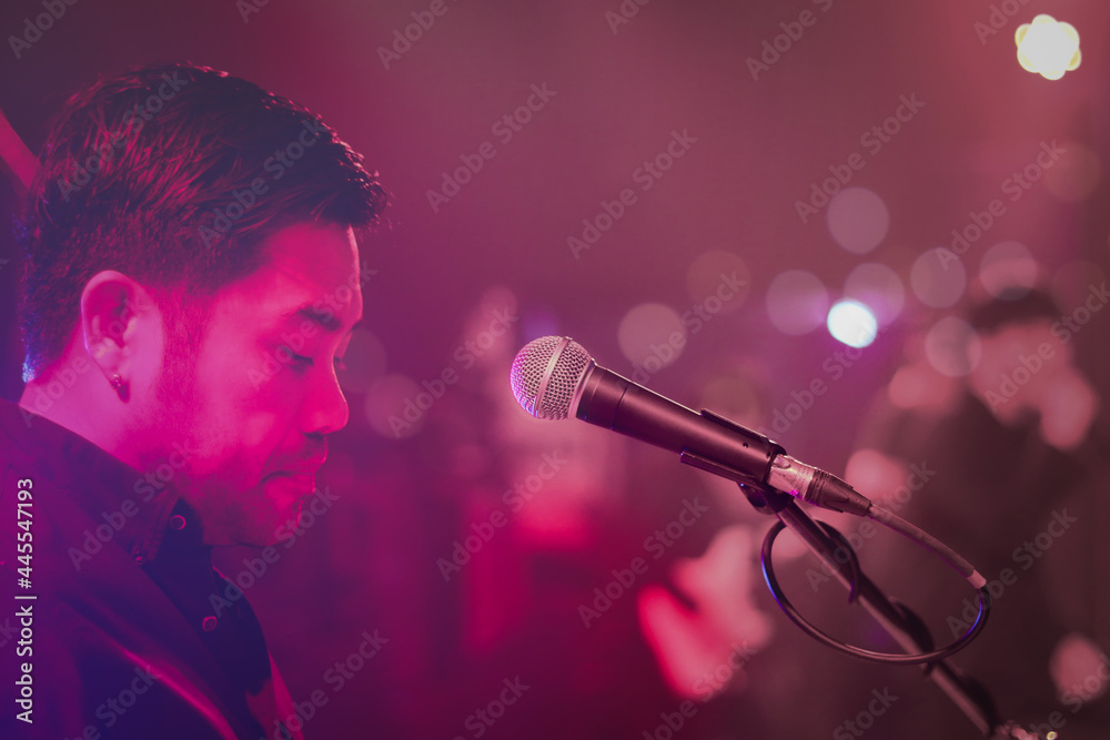 Obraz premium Close up of microphone for singer artist on stage with lighting bokeh at concert hall or conference room.