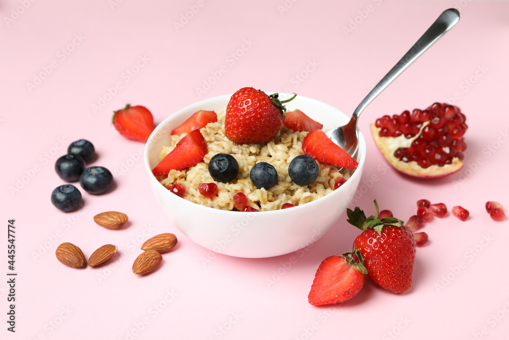 Concept of tasty eating with oatmeal on pink background