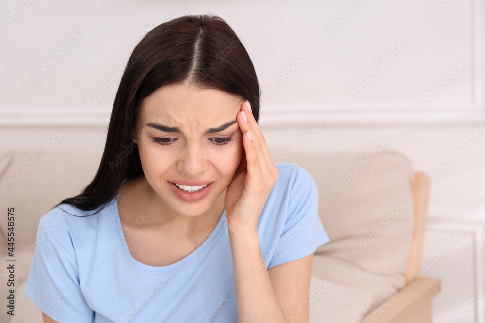 Young woman suffering from migraine at home, space for text Young woman suffering from migraine at home, space for text
