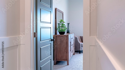 Pano Open door leading to a bedroom with cabinet mirror carpet floor and armchair