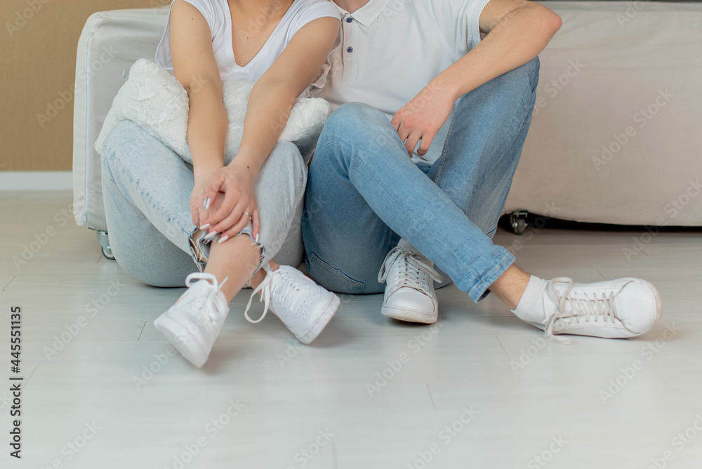 Fototapeta premium Legs Of Stylish Teen Friends or couple sitting inside. summer, education, campus, people and teenage concept - close up of students. Urban stylish trendy young teenage people with legs