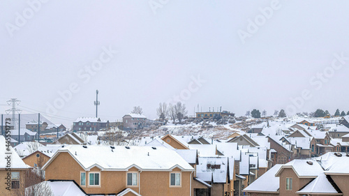 Pano Big and beautiful houses with white roofs with the white cloudy sky © Jason
