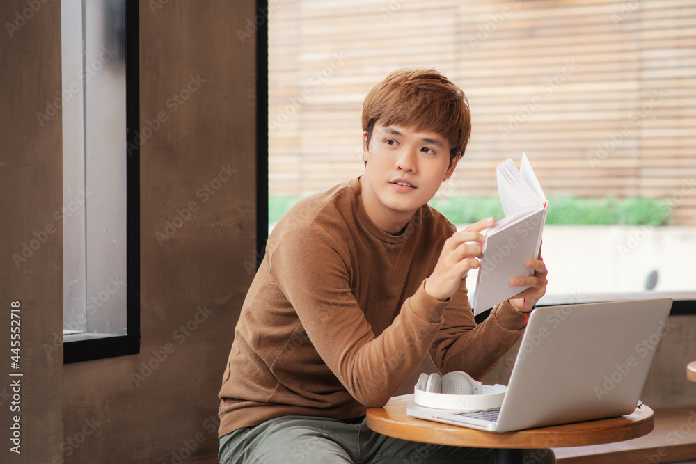 young serious asian man studying or working in coffee house young serious asian man studying or working in coffee house