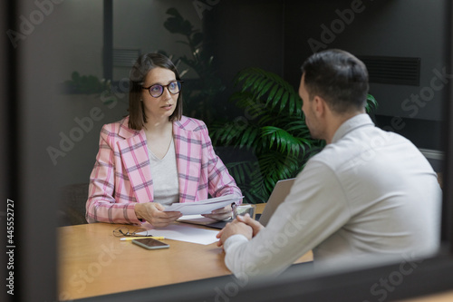 interview or negotiation, a successful and beautiful business woman in her office interviewing a man or discussing a work plan with a colleague or subordinate, hr specialist or psychologist