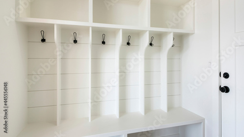 Pano Interior of a white mudroom with white garage door and wooden flooring