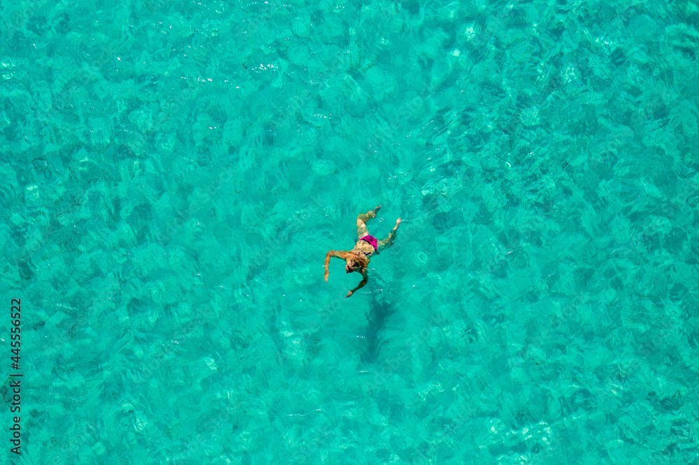 Aerial view of a girl floating in the turquoise sea of the Sakarun beach, Adriatic Sea, Croatia