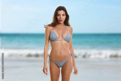 Beautiful woman in stylish bikini near sea