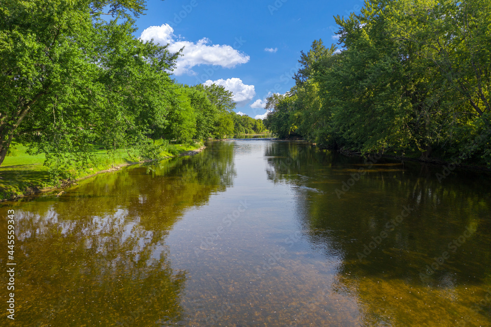 Beautiful clear river gentle blue skies and delightfully green trees. The Milwaukee River runs through Saukville WI