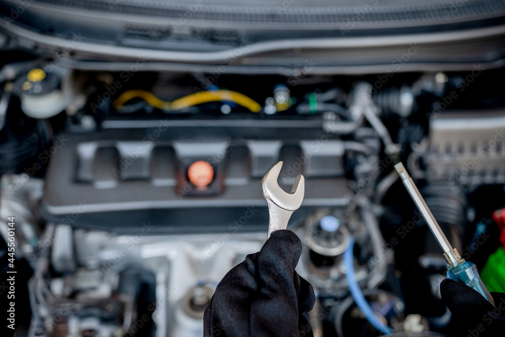 Technician is using a wrench and screwdriver for repair car in car service and maintenance concept Technician is using a wrench and screwdriver for repair car in car service and maintenance concept