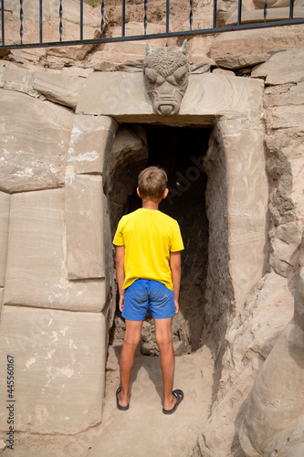 boy in the park in front of the cave entrance © vitec40